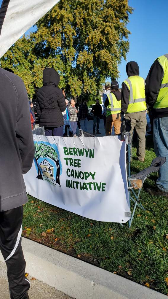 Photo of volunteers at BTCI tree planting event, around group banner.